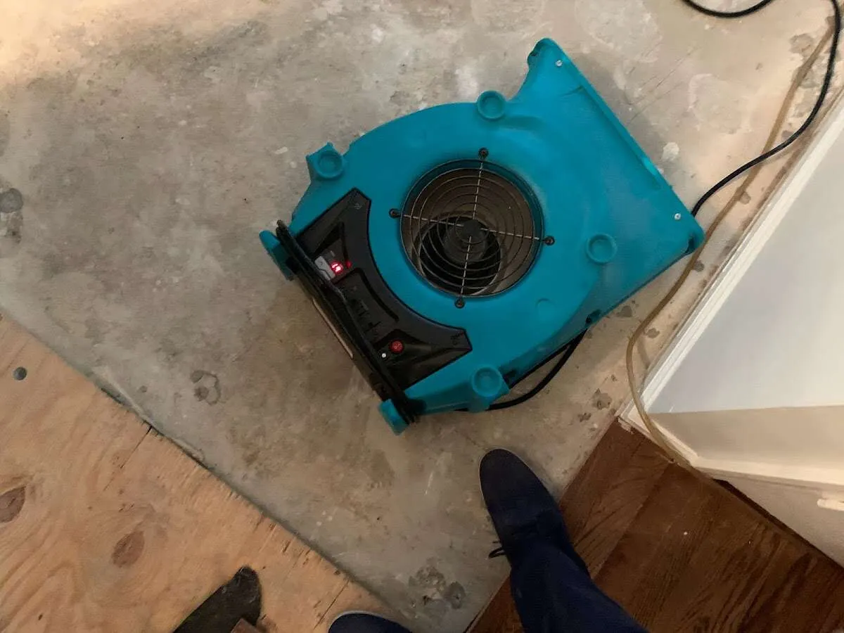 Air mover drying subfloor during Commercial Water Damage Restoration in Coralville